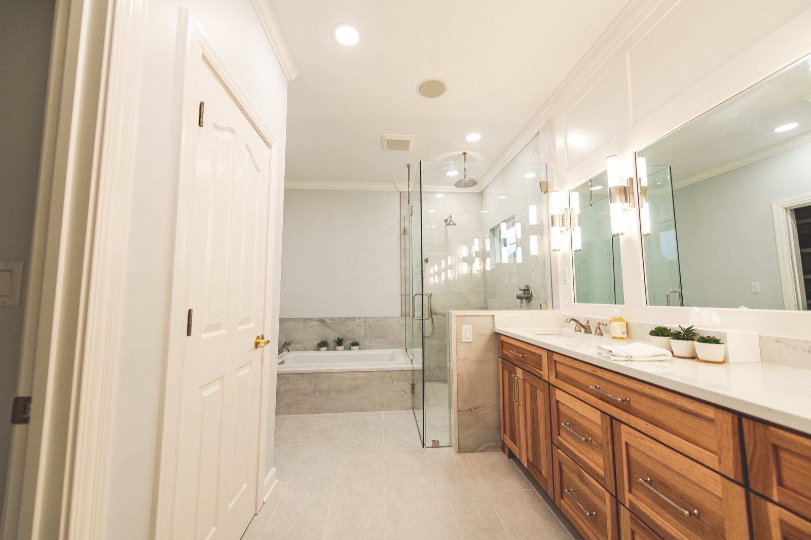 Walnut vanity with white quartz top, sconces between mirrors