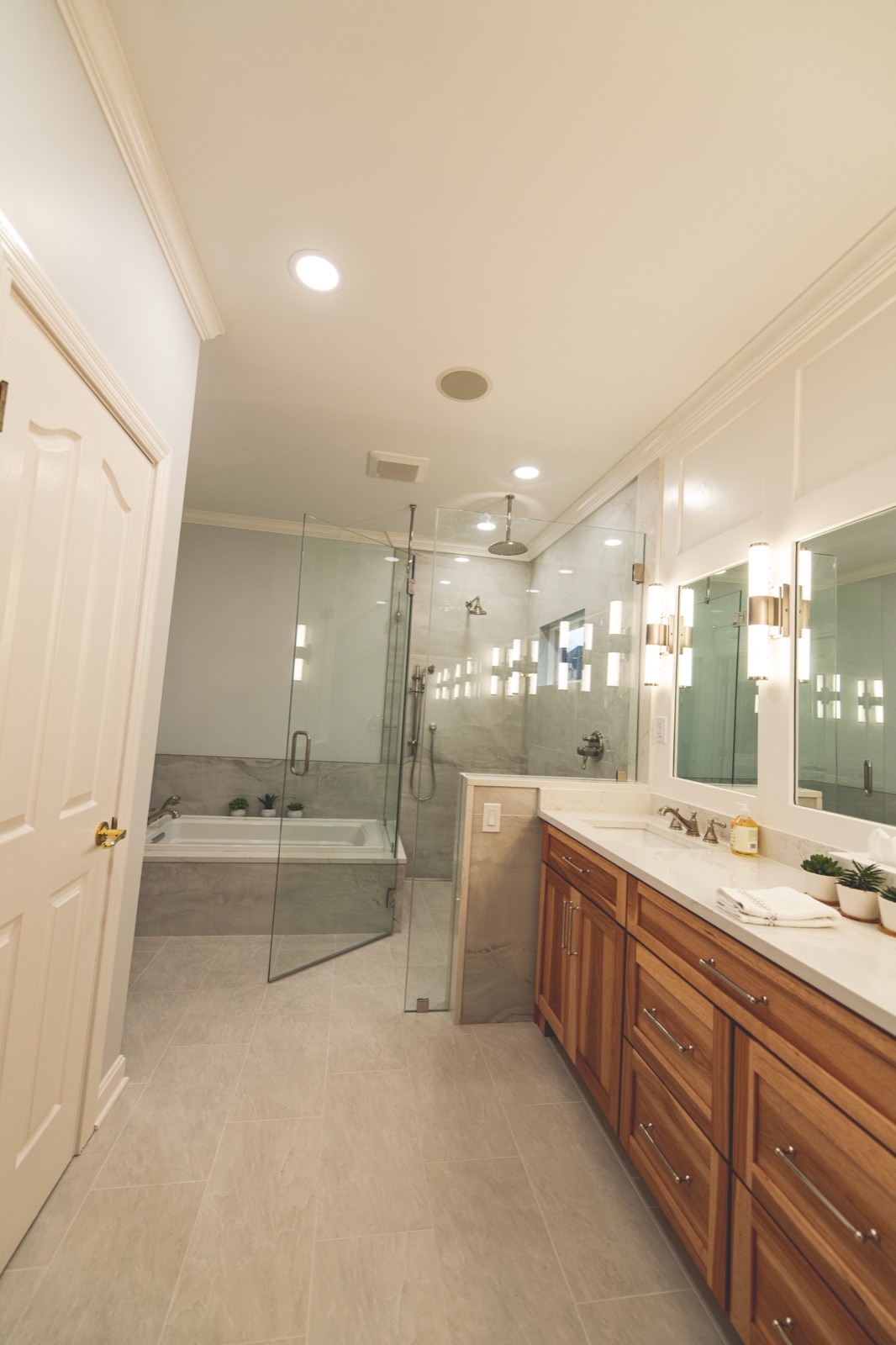 Walnut vanity with white countertop and large mirrors